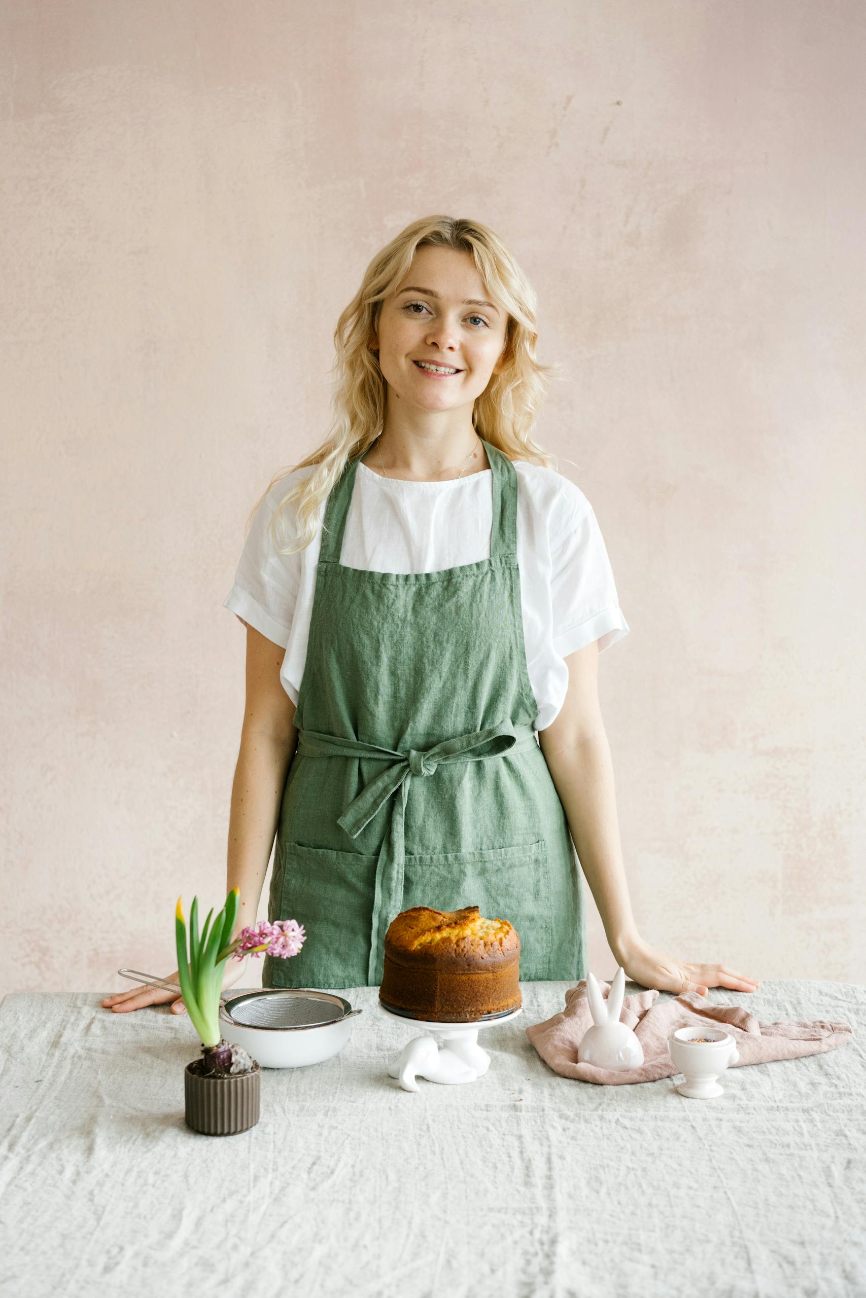 Photo of a Woman in a Green Apron Looking at the Camera