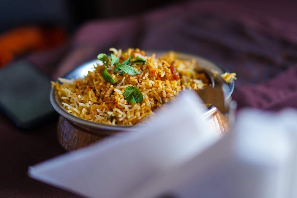 A delectable plate of biryani garnished with fresh herbs, showcasing vibrant food photography.